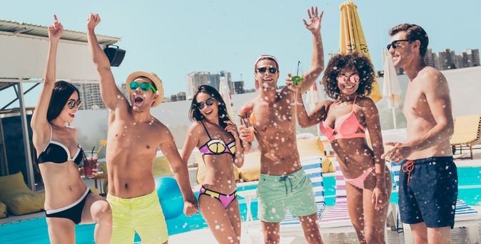 Gruppe von jungen Menschen feiert am Pool