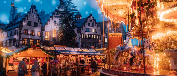 Ein Weihnachtsmarkt mit einigen Buden und einem hell erleuchteten Karussell