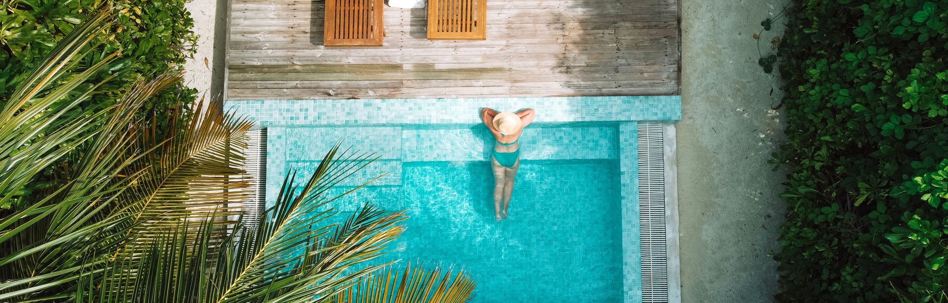 Eine Frau lehnt am Rand eines eleganten Pools