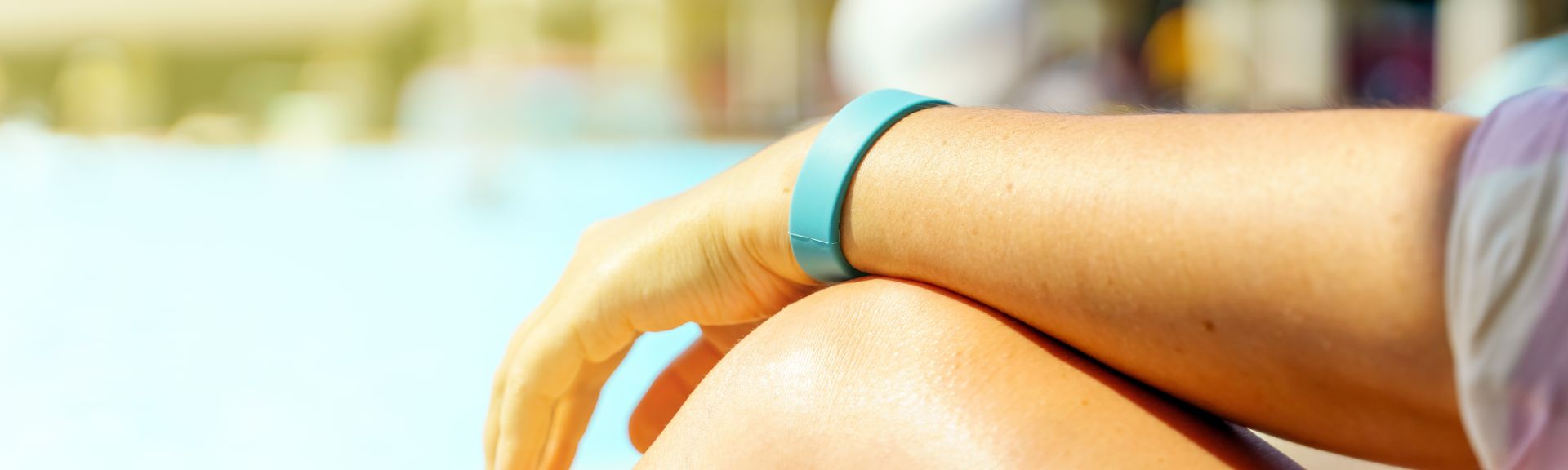 Hand mit einem Hotelarmband auf dem Hintergrund des Pools