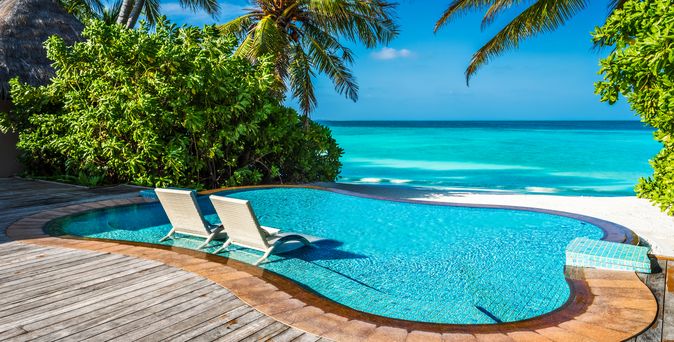 Ein kleiner Pool mit direktem Strandzugang und zwei Liegen