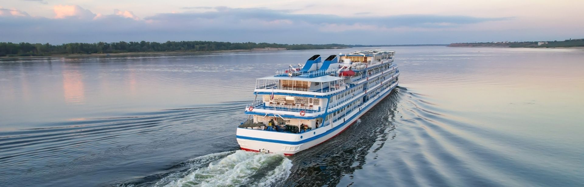 Flusskreuzfahrtschiff, dass auf einem breiten Fluss fährt