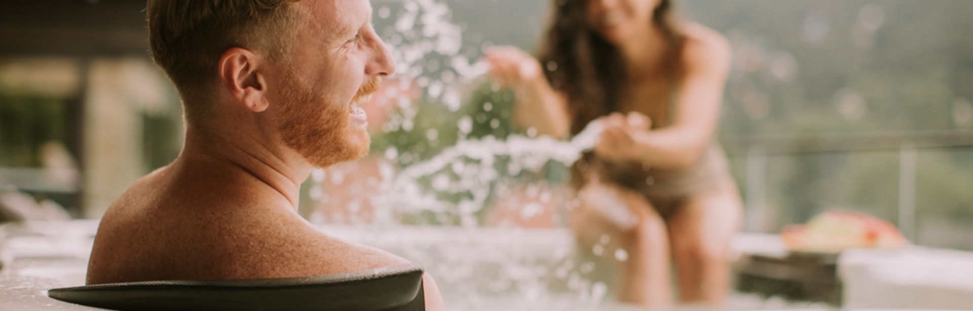 Ein Mann wird im Whirlpool von eine Frau nass gespritzt