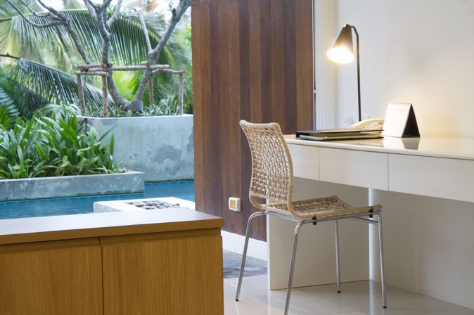 Ein Hotelzimmer mit Schreibtisch, im Hintergrund ein Swim-up Pool