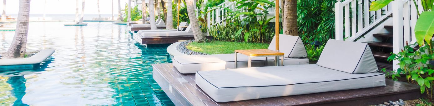 Zwei Liegen mit Sonnenschirm an einem Swim Up Pool