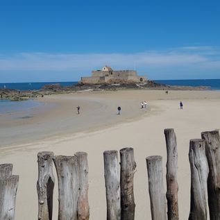 Blick über Holzzaun auf den Strand und das Fort Nationale in Saint Malo in der Bretagne in Frankreich