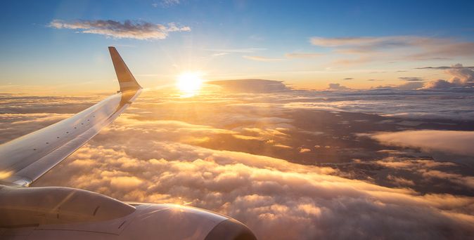 Sonnenuntergang über den Wolken aus einem Flugzeugfenster aus
