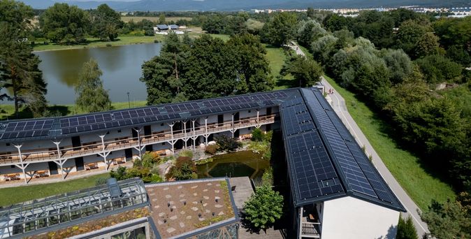Ein Hotel an einem See mit Solarplatten auf dem Dach