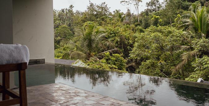 Blick auf einen Swim-up Pool mit Palmen im Hintergrund