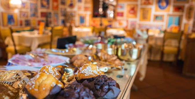 Eine Theke mit verschiedensten Gerichten, im Vordergrund sind Muffins zu sehen
