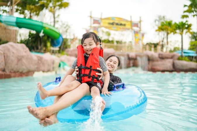 Mutter und Tochter auf einem Pool Floatie in einem Wasserpark