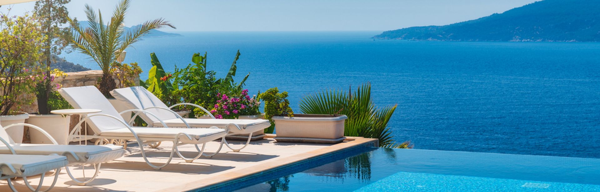 Infinity Pool mit Liegen und Blick auf das Meer
