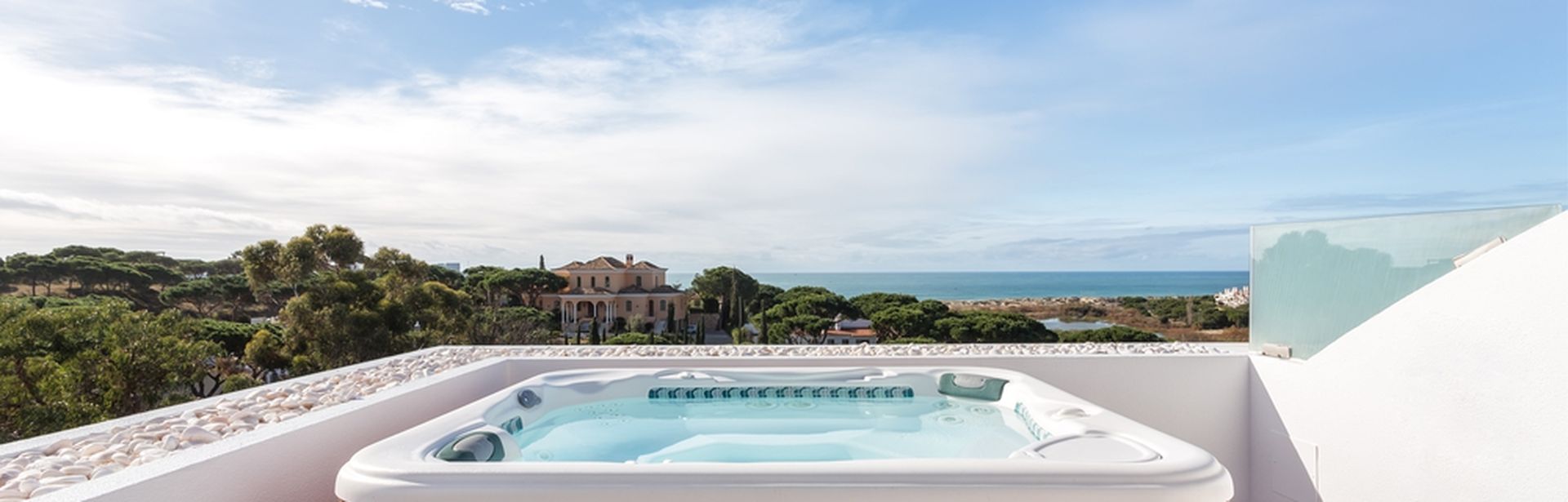 Ein Whirlpool auf einem Balkon mit weißer Brüstung bei Sonnenschein