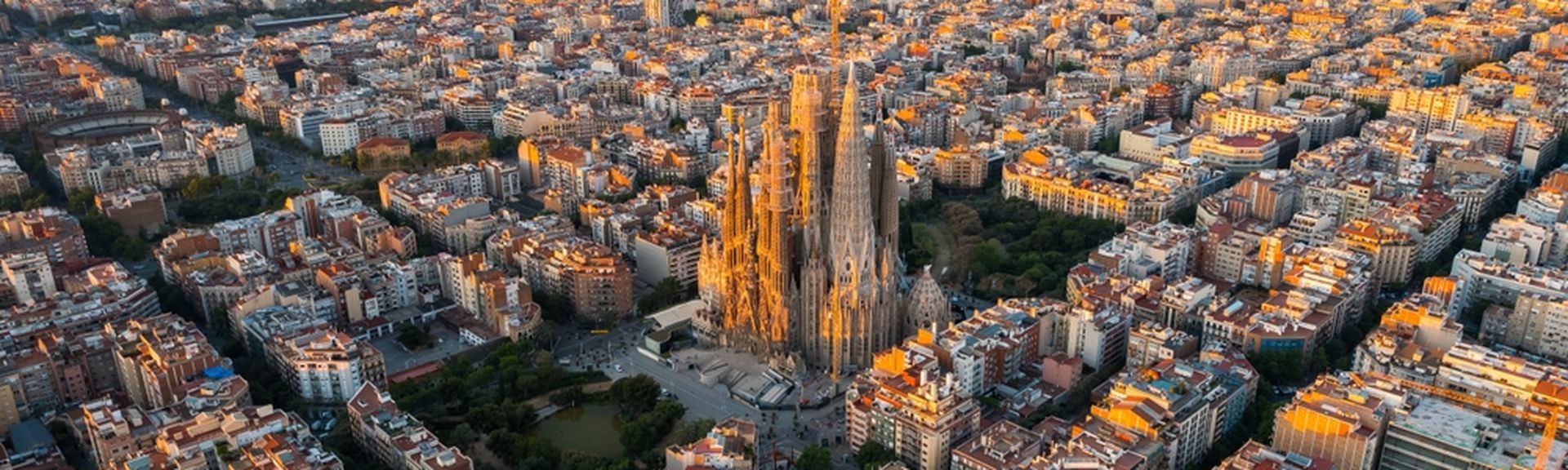 Barcelona von oben bei Sonnenuntergang, im Hintergrund das Meer