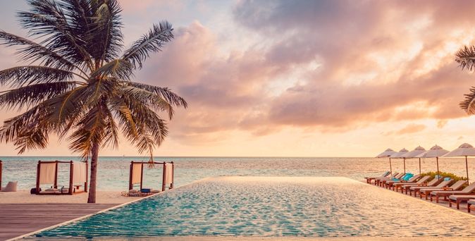 Ein Pool mit Meerblick bei Sonnenuntergang