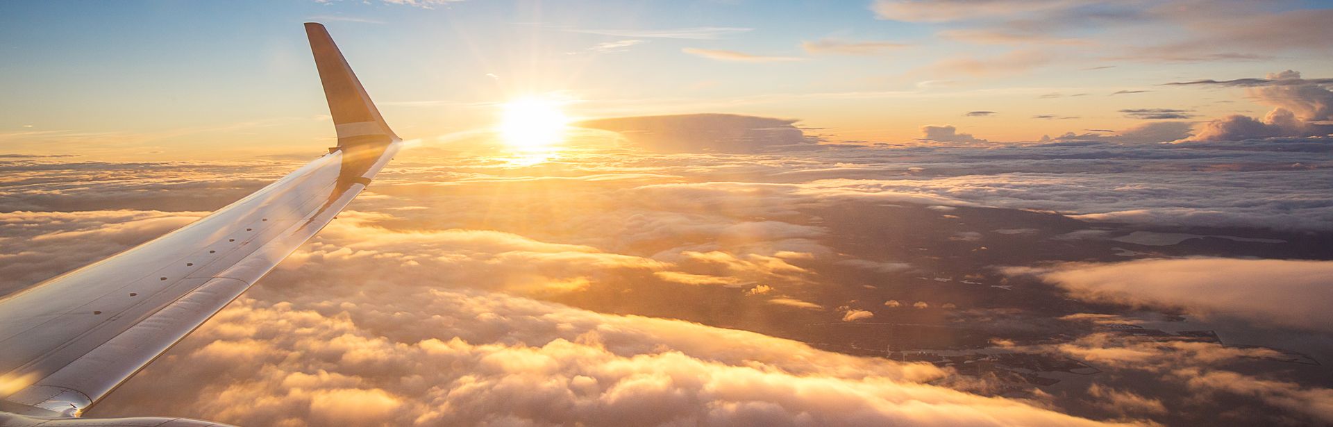 Sonnenuntergang über den Wolken aus einem Flugzeugfenster aus