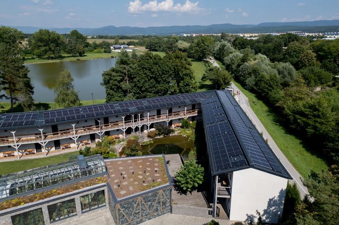 Ein Hotel an einem See mit Solarplatten auf dem Dach