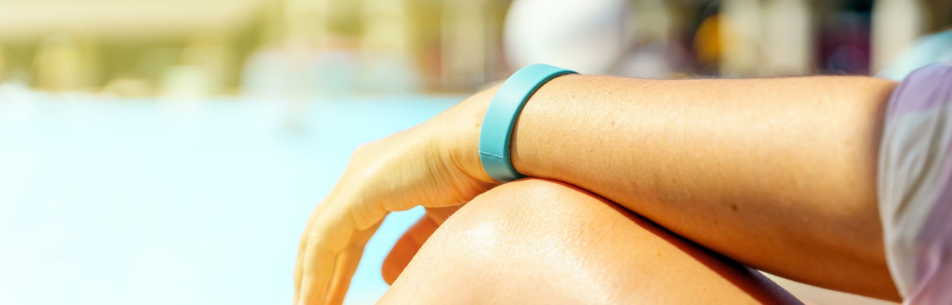 Hand mit einem Hotelarmband auf dem Hintergrund des Pools