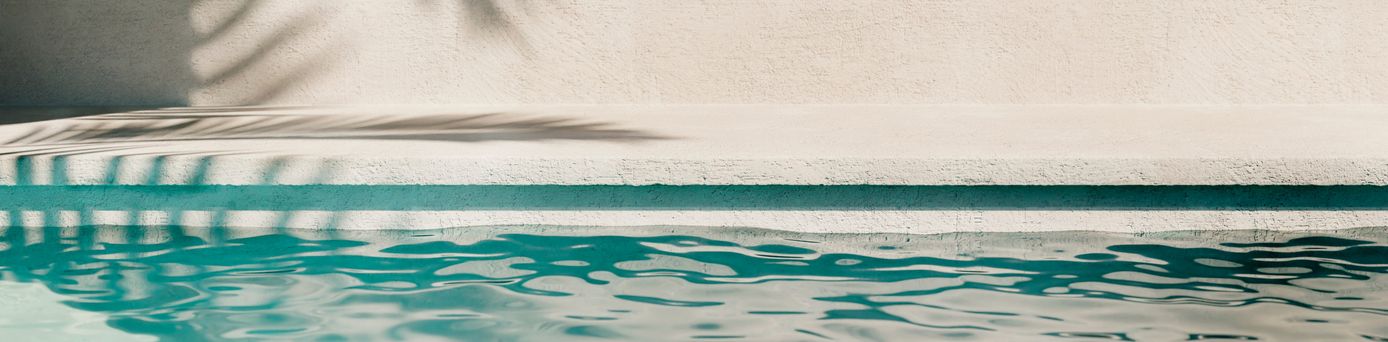 Poolwasser, auf der Wand im Hintergrund sieht man den Schatten einer Palme