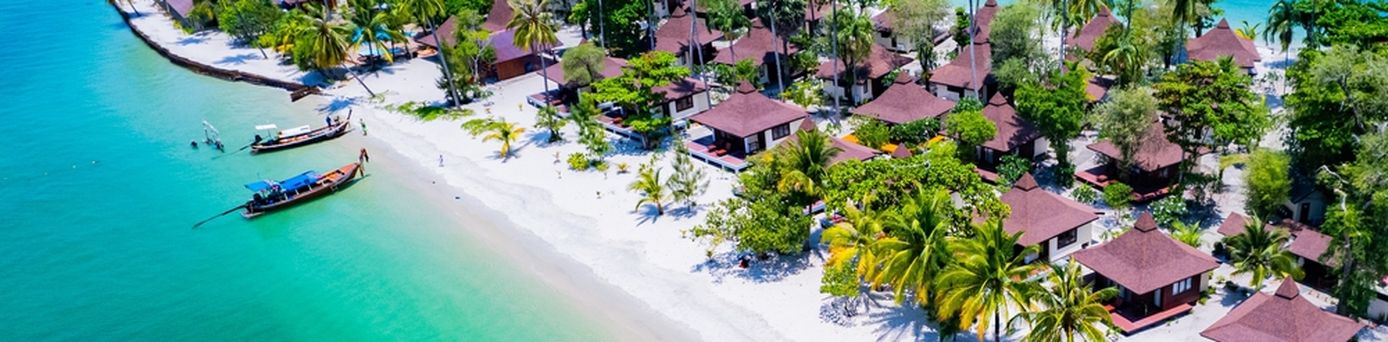 Teil einer Insel mit kleinen Häusern und Palmenstrand