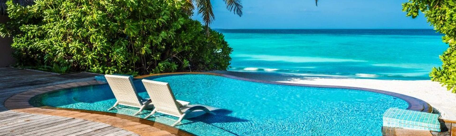 Ein kleiner Pool mit direktem Strandzugang und zwei Liegen