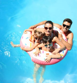 Eine Familie mit zwei Kindern und ein Schwimmreifen in einem Pool