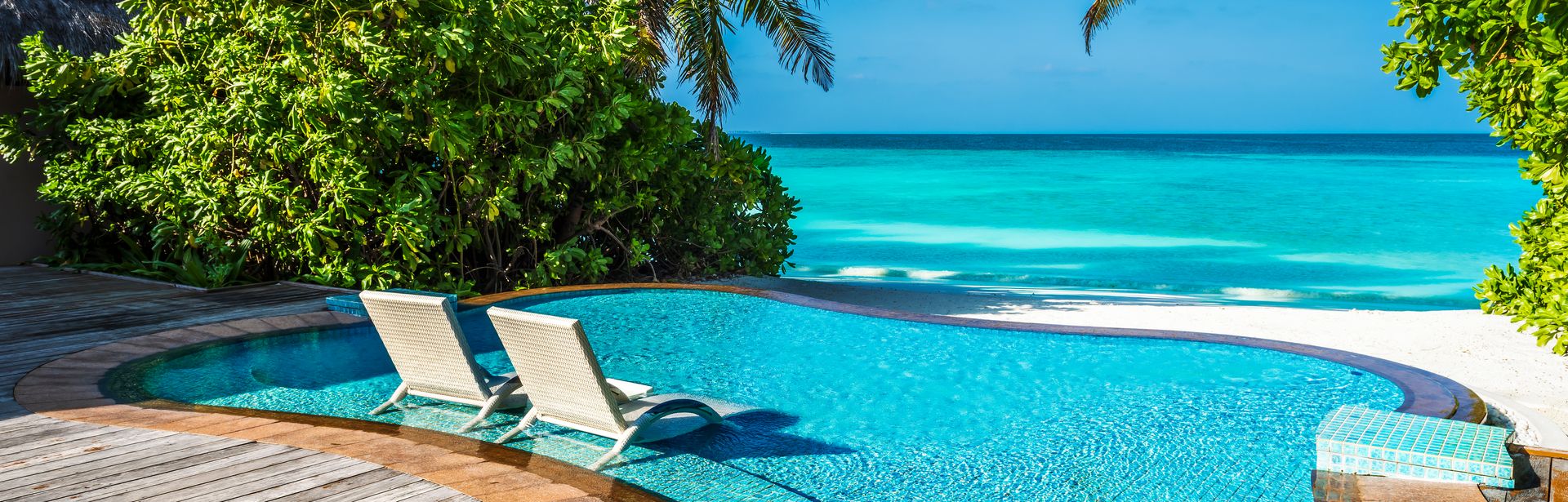 Ein kleiner Pool mit direktem Strandzugang und zwei Liegen