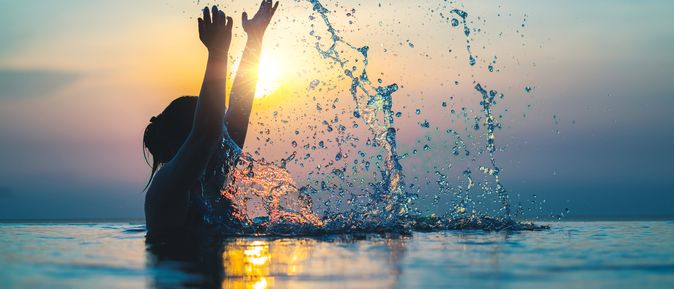 Frau im Pool bei Sonnenuntergang 