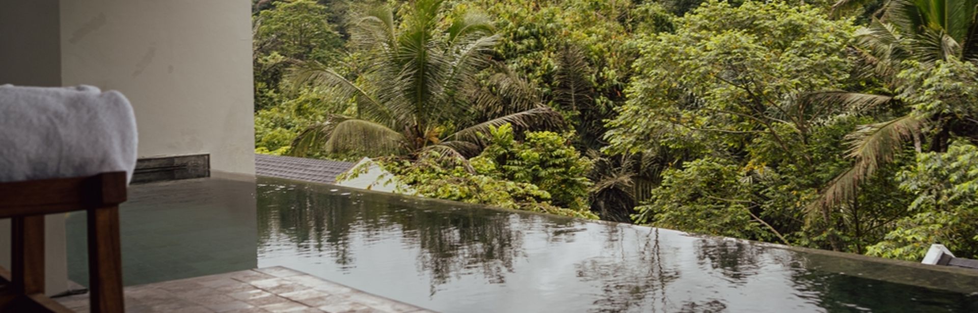 Blick auf einen Swim-up Pool mit Palmen im Hintergrund