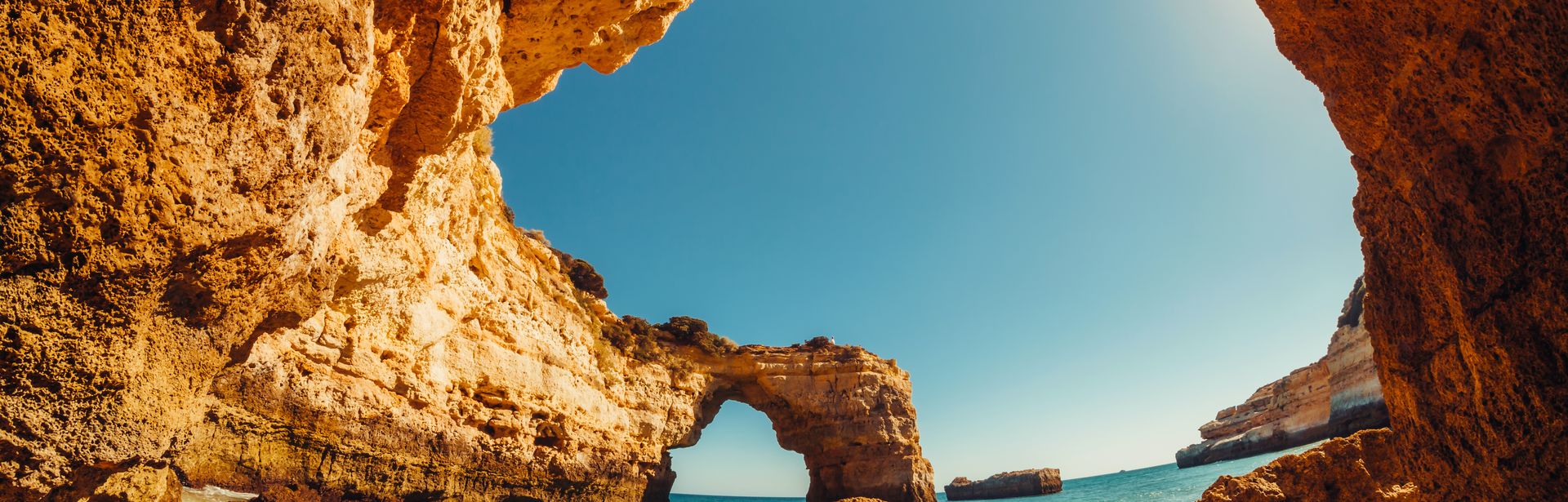 Blick auf einen Strand unter einem Felsdach.