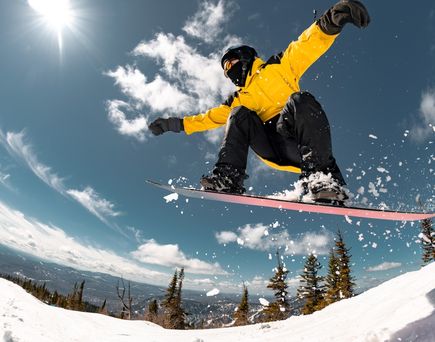 Mann auf einem Snowboard springt in der Luft