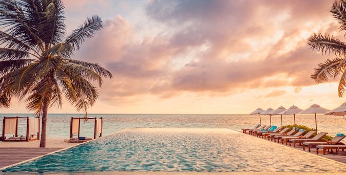 Ein Pool mit Meerblick bei Sonnenuntergang
