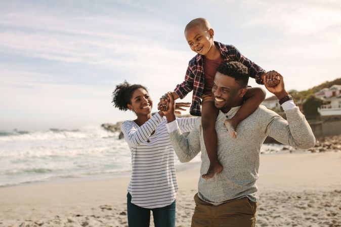 Eine Familie am Strand, Sohn sitzt auf den Schultern des Vaters