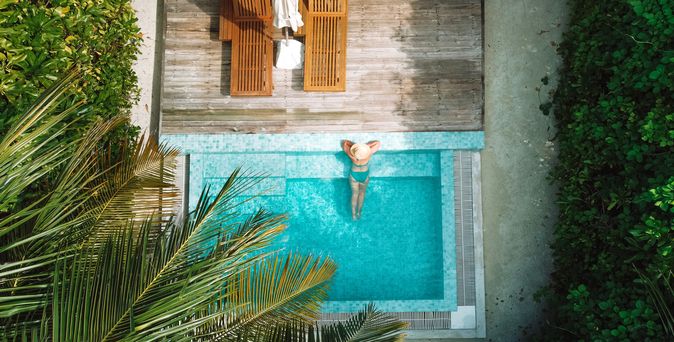 Eine Frau lehnt am Rand eines eleganten Pools