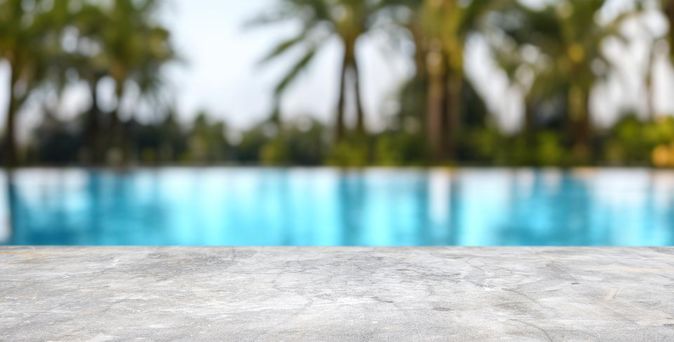 Ein Pool mit verschwommenen Palmen im Hintergrund