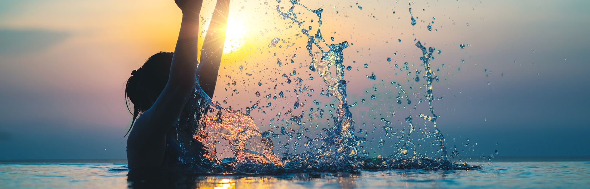 Frau im Pool bei Sonnenuntergang 