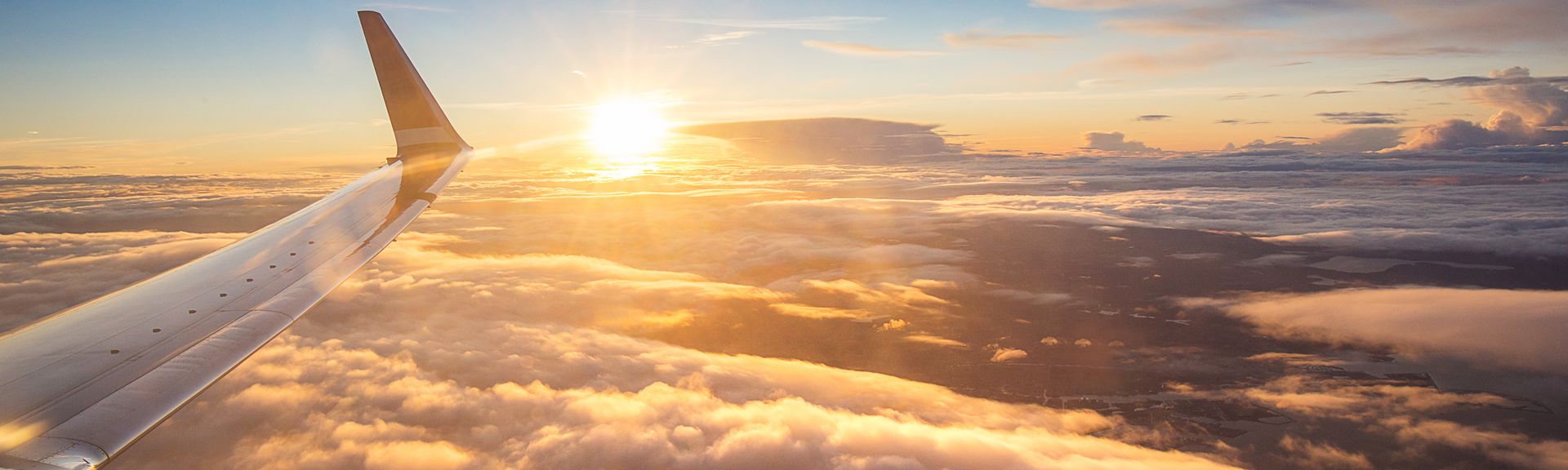 Sonnenuntergang über den Wolken aus einem Flugzeugfenster aus