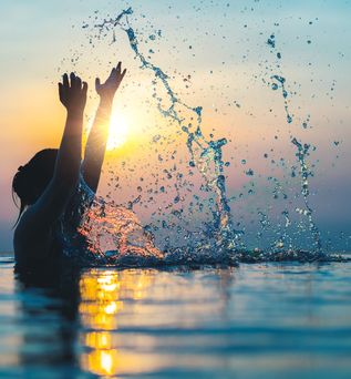 Frau im Pool bei Sonnenuntergang 
