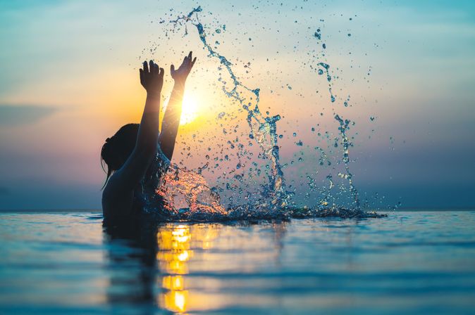 Frau im Pool bei Sonnenuntergang 