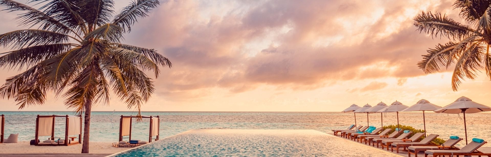 Ein Pool mit Meerblick bei Sonnenuntergang