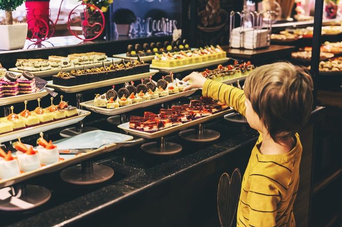 Ein Kind bedient sich an einem Dessertbuffet