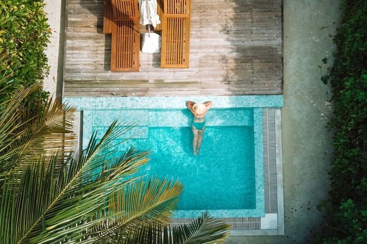 Eine Frau lehnt am Rand eines eleganten Pools