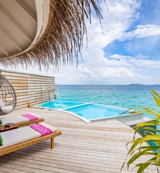 Eine Terrasse mit Privatpool und gemütlichen Liegen über dem Meer