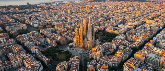 Barcelona von oben bei Sonnenuntergang, im Hintergrund das Meer