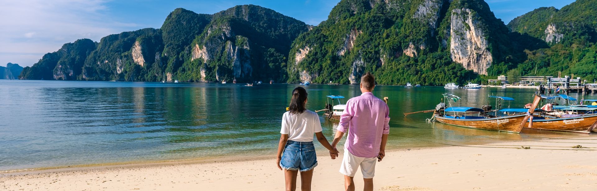 Ein Paar steht am Strand und hält Händchen