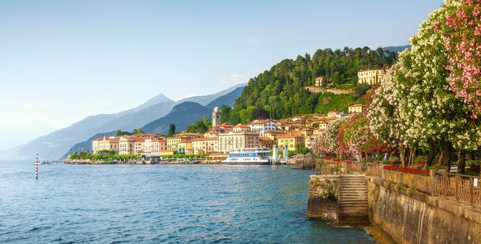 Kante zu einem Meer mit blühenden Bäumen und einer Stadt im Hintergrund