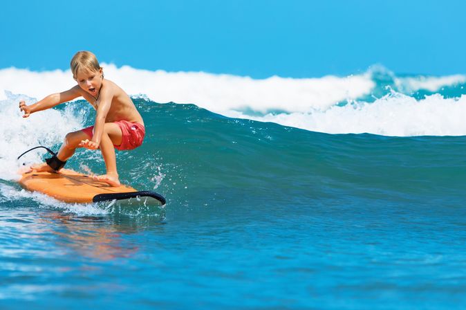Junge surft auf einer Welle