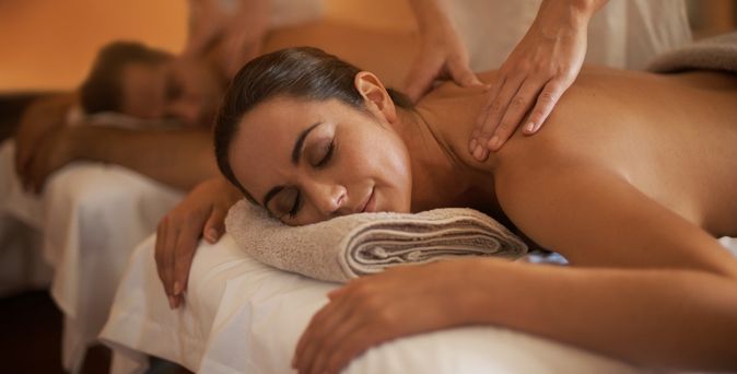 Eine Frau und ein Mann werden auf Massageliegen massiert