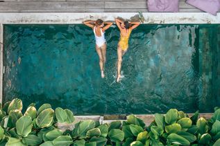 Zwei Frauen liegen im Pool und schauen sich an