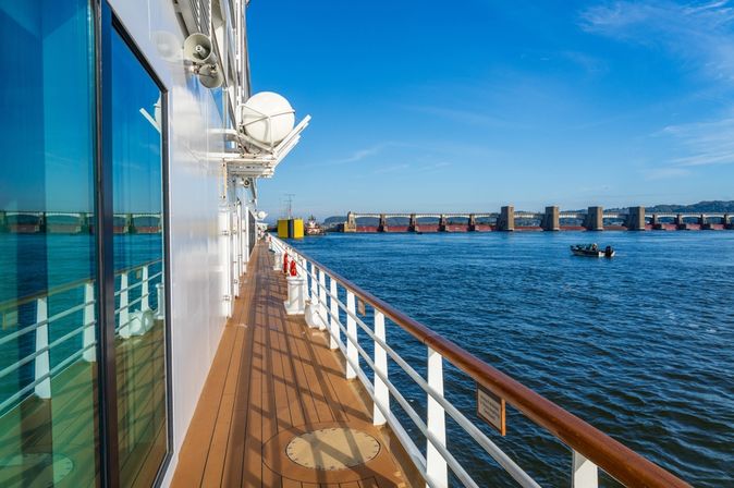 Seite eines Flusskreuzfahrtschiffes mit Blick auf den Fluss